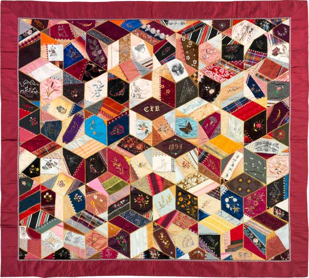 A crazy quilt whose irregular fabric scraps are fit into a lattice of diamonds.
